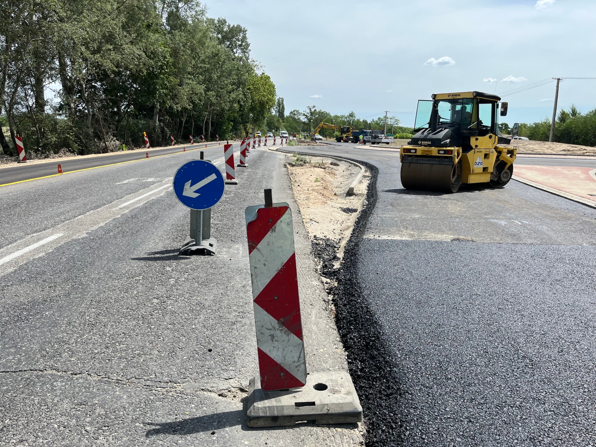 Körforgalom építése piros-fehér terelőoszlopokkal és BOMAG hengerrel